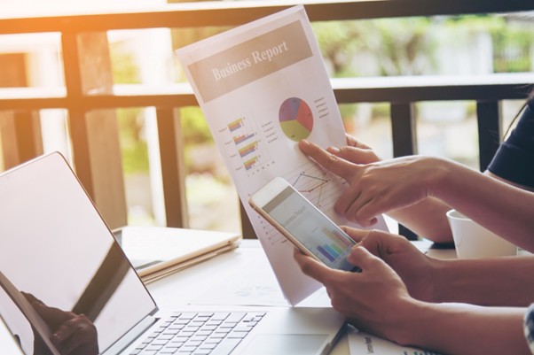  Team reviewing charts and mobile data while reporting on ad campaign results.