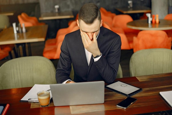 Frustrated lawyer reviewing laptop at a desk, representing costly mistakes and wasted budget in PPC advertising campaigns.