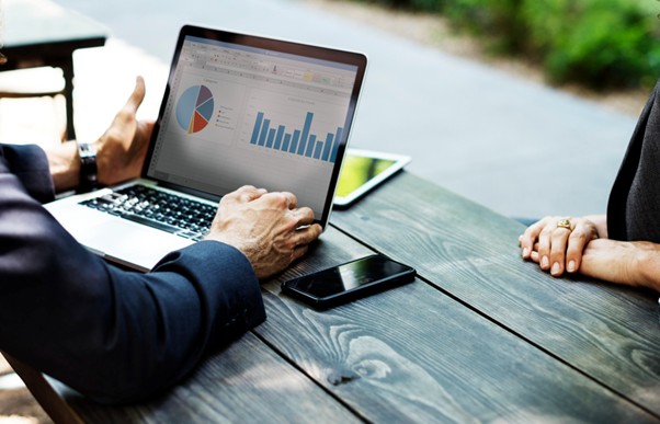 People analyzing SEO ranking factors on a laptop with charts and data in a workspace.