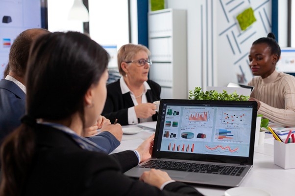 Business team analyzing marketing performance charts on laptop.